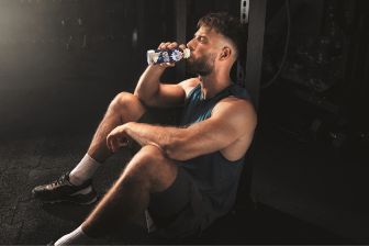 Mann trinkt im Gym Emmi Energy Milk